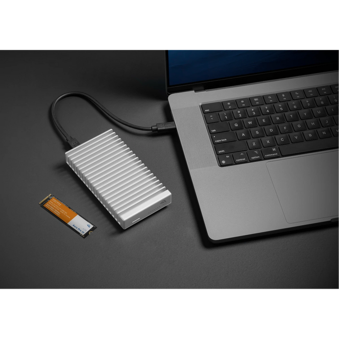 OWC Express 1M2 80G external SSD drive attached to a laptop besides a SSD blade
