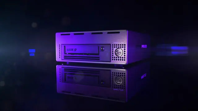 SymplyPRO Thunderbolt 3 compact desktop form factor viewed from the front, angled to the left and illuminated with a purple light while being on a black background